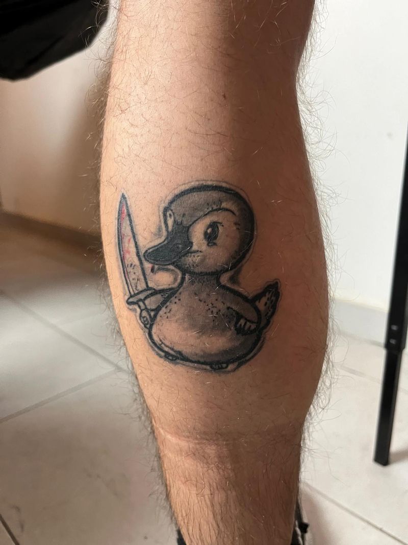 Cartoon rubber duck holding a bloodied knife, black and grey with red, on a calf