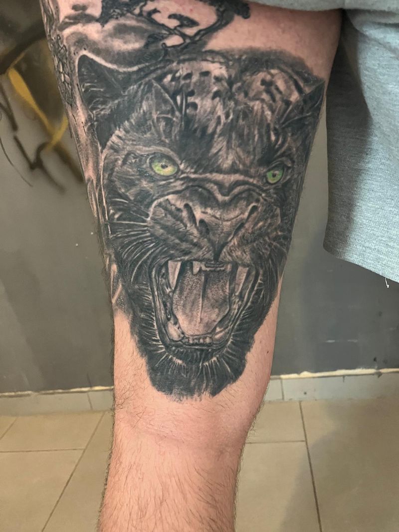 Photorealistic snarling panther on a leg, black and grey with green eyes